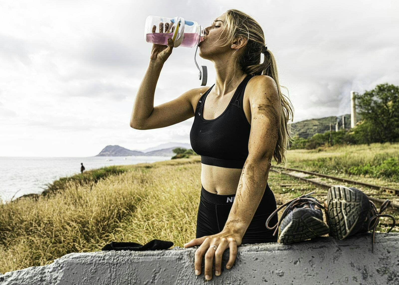 Best way to replenish electrolytes: Athlete drinking DripDrop ORS outdoors