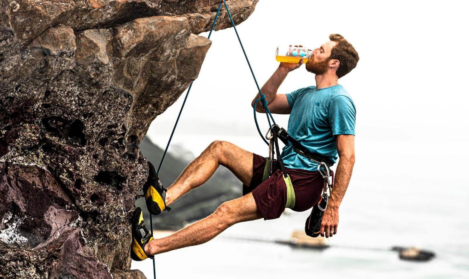 Drip Drop vs Gatorade: Man drinking DripDrop ORS while rock climbing
