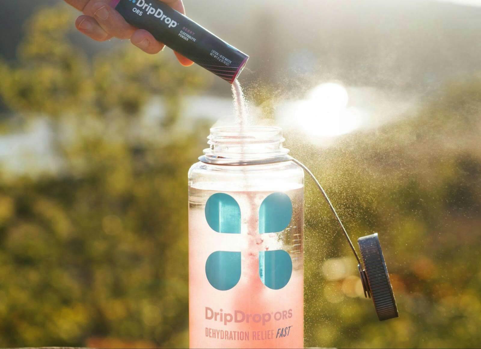 Is water an electrolyte: person pouring a DripDrop ORS sachet into a bottle